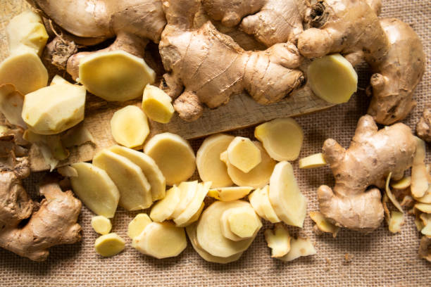 Ginger root and sliced ​​ginger fruit on a wooden table